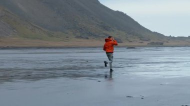 İzlanda Kara Kum Plajını Keşfeden Adam, Turuncu Ceketli Maceracı Solo Gezgin