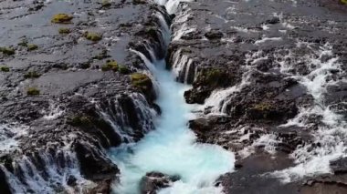 Bruarfoss şelalesi, İzlanda 'nın en mavi şelalesi turkuvaz suları ve kayalık çağlayanlarla hava manzaralı doğal güzellikler sergiliyor. İkonik bir İzlanda manzarası.