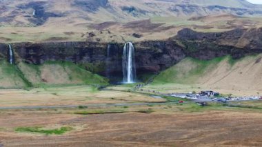 Yaz boyunca İzlanda 'nın güney bölgesindeki Seljalandsfoss şelalesinin hava manzarası, popüler bir turizm merkezi..