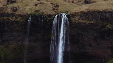 Yaz boyunca İzlanda 'nın güney bölgesindeki Seljalandsfoss şelalesinin hava manzarası, popüler bir turizm merkezi..