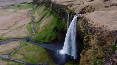 Yaz boyunca İzlanda 'nın güney bölgesindeki Seljalandsfoss şelalesinin hava manzarası, popüler bir turizm merkezi..