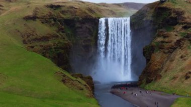 Skogafoss şelalesi, ünlü doğal bir dönüm noktası ve seyahat yeri. Yaz boyunca İzlanda 'nın etkileyici güzellikte doğası