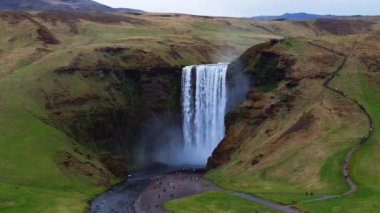 Skogafoss şelalesi, ünlü doğal bir dönüm noktası ve seyahat yeri. Yaz boyunca İzlanda 'nın etkileyici güzellikte doğası