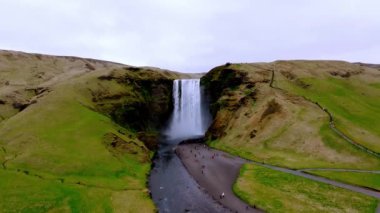 Skogafoss şelalesi, ünlü doğal bir dönüm noktası ve seyahat yeri. Yaz boyunca İzlanda 'nın etkileyici güzellikte doğası