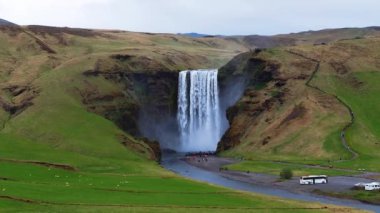 Skogafoss şelalesi, ünlü doğal bir dönüm noktası ve seyahat yeri. Yaz boyunca İzlanda 'nın etkileyici güzellikte doğası