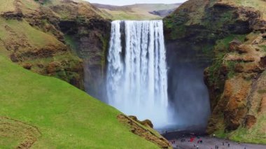 Skogafoss şelalesi, ünlü doğal bir dönüm noktası ve seyahat yeri. Yaz boyunca İzlanda 'nın etkileyici güzellikte doğası