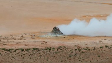 Haukadalur, İzlanda 'daki Geysir Vadisi' nin hava manzarasında jeotermal kaplıcalar ve buharlı bacalar yer alıyor..