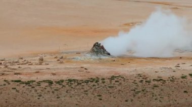 Haukadalur, İzlanda 'daki Geysir Vadisi' nin hava manzarasında jeotermal kaplıcalar ve buharlı bacalar yer alıyor..