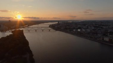 Letonya 'nın Riga şehrinin manzarasını birbirine bağlayan birden fazla köprüyle Daugava Nehri üzerinde sersemletici bir gün batımı..