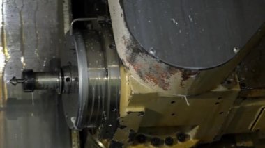 Metal işleme makinesi aktif bir metal parçası, kesme aletleri ve metal talaşları görünür. Isı ve sürtünmeyi azaltmak için soğutucu püskürtülür..