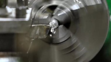 Metal torna, metal talaşları üreten kesici bir aletle dönen bir atölyeyi şekillendirir. Hareket bulanıklığı dinamik makine işlemini vurgular.