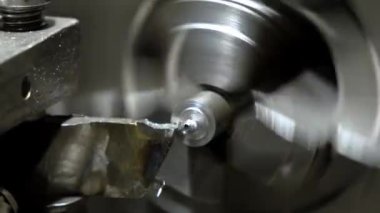 Metal torna, dönen bir çalışma şeklini alan kesici bir aletle iş başında. Hareket bulanıklığı, makine sürecinin hassasiyetini ve hızını vurgular.
