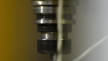 Kesici bir alet aktif olarak metal makineler, kıvılcımlar ve talaşlar fırlatıyor. Bulanık arkaplan endüstriyel sürecin hassasiyetini ve hızını vurgular.