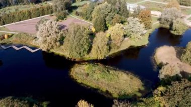 Botanik bahçesinin hava perspektifi zigzag su yolunu, yemyeşil ağaçları ve patikalı bahçeleri ön plana çıkarıyor..