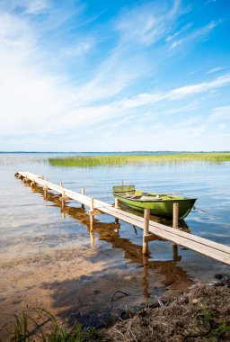 Yaz güneşli gün sabah içinde demirleyen gölde bir iskelede balıkçı teknesi