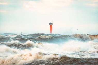 Riga, Letonya 'da fırtınalı havalarda deniz feneri. Büyük dalgalar sahile vuruyor.