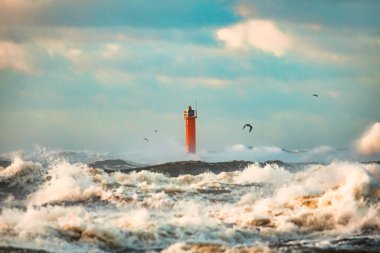 Riga, Letonya 'da fırtınalı havalarda deniz feneri. Büyük dalgalar sahile vuruyor.