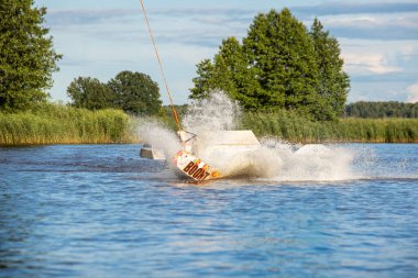 Wakeboard ve su sporları aktiviteleri. Gölde sörf yapan bir adam. Yazın su kayağı.