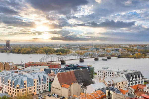 Gün batımında Riga, Letonya 'da demiryolu köprüsü ve eski kasaba