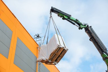 Bir Crane 'in Mavi Gök' e Karşı Paketli Paleti Kaldırışının Yüksek Açı Görünümü
