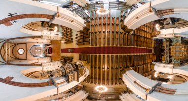 Görüntü bir katedralin iç kısmının havadan görüntüsünü yakalıyor, simetrik sıra sıralarını, süslü bir sunağı, karmaşık tavan tasarımlarını ve organ borularını vurguluyor..