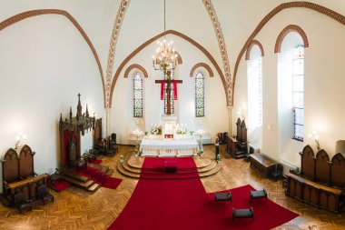 Kilisenin içinde yüksek kemerli tavanlar, karmaşık tuğlalar ve vitray pencereler bulunur. Sunak beyaz kumaş ve çiçeklerle süslenmiş..