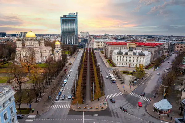 Riga, Letonya 'nın havadan görünüşü, İsa' nın Doğumu Katedrali 'nin altın kubbeleri, ağaç kaplı bir bulvar, ve günbatımında modern bir gökdelen..