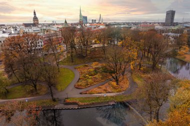 Riga, Letonya 'nın şehir manzarası Riga Katedrali' nin kulesi, sonbahar yaprakları ve Daugava Nehri. Vansu Köprüsü, tarihi gökyüzüne modern bir dokunuş katıyor..