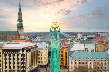 Bu görüntü Letonya 'nın Riga kentinin havadan görünüşünü, Özgürlük Anıtı' nı ve tarihi bir şehir manzarasına karşı Aziz Peter Kilisesi 'nin kulesini vurguluyor..