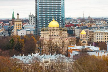 Riga, Letonya 'nın havadan görünüşü, İsa' nın Doğumu Katedrali 'ni altın kubbelerle vurguluyor, sonbahar yaprakları arasında modern ve tarihi binalarla çevrili..