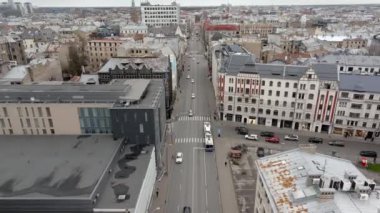 Riga, Letonya 'da yoğun bir caddenin hava perspektifi, çeşitli mimari, araçlar, tramvay ve bulutlu gökyüzü altında dokulu çatılar.