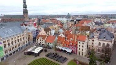 Riga, Letonya 'nın ufuk çizgisinde Aziz Peter Kilisesi kulesi, renkli binalar ve kırmızı kiremitli çatılar yer almaktadır. Daugava Nehri ve Ulusal Kütüphane görülebilir..