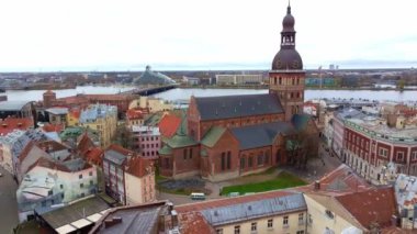 Görüntüde Riga, Letonya 'nın Riga Katedrali ve saat kulesi yer alıyor. Daugava Nehri ve Ulusal Kütüphane görülebilir..