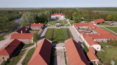 Pakruojis Malikanesi, bir avlu etrafında kırmızı çatılı binalar, canlı lale bahçeleri ve bereketli ağaçlar tarafından çerçevelenmiş önemli bir ana binaya sahiptir..