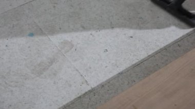 Video, mavi boya izleriyle dokulu bir alt kattan parlak ahşap bir zemine geçişi kaydediyor..