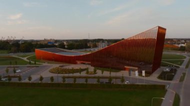 Ventspils Konser Salonu Latvija, Letonya 'nın Ventspils kentinde şehir manzarası ve endüstriyel vinçlerle çevrili, pas gibi bir ön cephesi olan modern açısal bir tasarıma sahiptir..