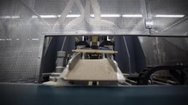Üretim ortamında merkezi taşıma bandı materyalleri. Metalik paneller, borular ve yapay ışıklandırma üretim ortamını vurgular.