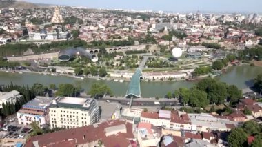 Gürcistan 'ın Kura Nehri, Barış Köprüsü, Rike Parkı yapıları ve çeşitli mimarinin ortasında yer alan Kutsal Üçlemeci Katedrali manzarası.