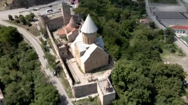 Gürcistan 'daki Ananuri Kalesi' nde konik bir kilise, taş duvarlar ve kuleler yer almaktadır..