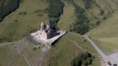 14. yüzyıldan kalma taş bir yapı olan Gergeti Trinity Kilisesi, dağ yamaçları, vadileri ve seyrek bitki örtüsüyle çevrili 2170 metrelik bir tepenin üzerinde yer alır..