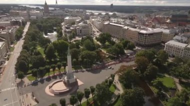 Letonya 'nın Riga kentindeki Özgürlük Anıtı, yeşil parklar, tarihi binalar ve Daugava Nehri ile çevrili bir maraton etkinliğinin ortasında büyük bir meydanda duruyor..