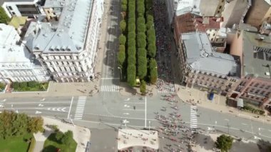 Riga, Letonya 'da bir maraton etkinliği, simetrik ağaçlar, farklı mimari ve kentsel etkinliğin yer aldığı bir caddenin havadan perspektifi.