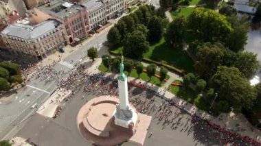 Letonya 'nın Riga kentindeki Özgürlük Anıtı' nın hava manzarası maraton katılımcıları, parklar, tarihi binalar ve canlı etkinliklerle çevrili..