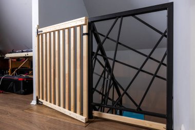 Çifte güvenlik kapılarında tahta çıtalar ve ahşap zeminde siyah metal çapraz desenler bulunur. Çalışma alanı ve eğimli tavan çatı katı ayarları önerir.