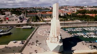 Keşifler Anıtı, Portekiz 'in Lizbon kentinin arka planında bulunan marinada ve Jeronimos Manastırı' nda tekneleri bulunan Tagus Nehri kıyısında duruyor..