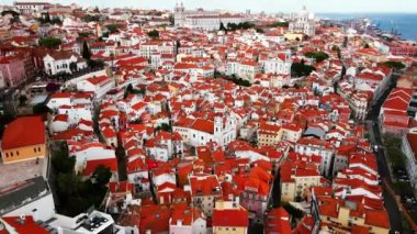 Kırmızı kiremitli çatılar, dar sokaklar ve Sao Vicente de Fora Kilisesi ve Ulusal Panteon gibi simgelerden oluşan canlı Lizbon şehri..