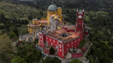 Portekiz 'in Sintra kentindeki Pena Sarayı, ormanlık tepeler ve 19. yüzyıl romantizm tarzıyla çevrili kırmızı ve sarı kuleli eklektik mimariye sahiptir..