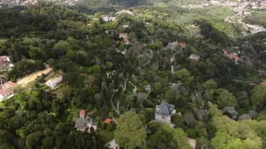 Hava manzarası Portekiz 'in Sintra kentindeki yoğun ormanın ortasında Quinta da Regaleira' yı vurgular, tarihi mimari ve dolambaçlı yollar boyunca görülebilir..