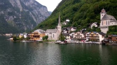 Avusturya 'daki Hallstatt köyünde ikonik Lüterci kilisesi, renkli evler, ormanlık tepeler ve sakin Hallstatter gölünün yanındaki kayalıklar yer almaktadır..