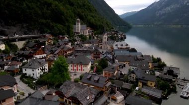 Avusturya 'daki Hallstatt' te geleneksel mimari, renkli evler ve orman tepeleri ve yansıtıcı göle karşı inşa edilen Evanjelik Kilise kulesi yer alıyor..